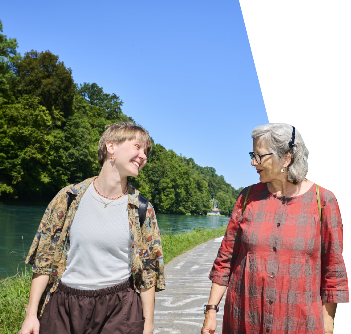 Zwei Frauen spazieren lachend an der Aare